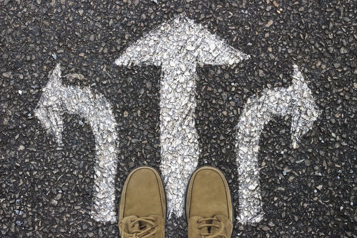 image of thre directional arrows painted in white on asphalt road with a pair of mens tan shoes for story he's taking a chance by author jenisecook.com