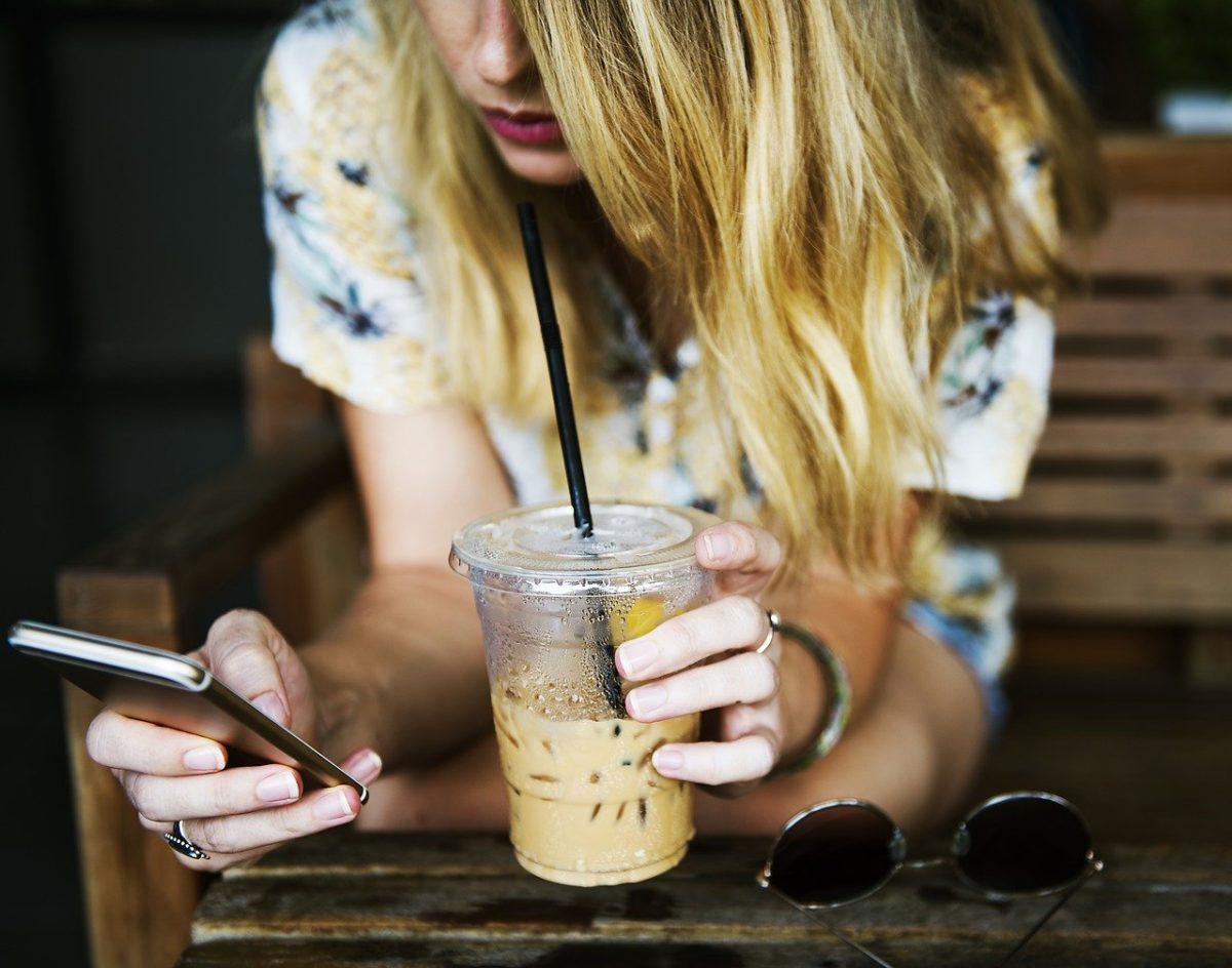 image of young woman with coffee and smartphone for story are you talking to me by author jenisecook.com