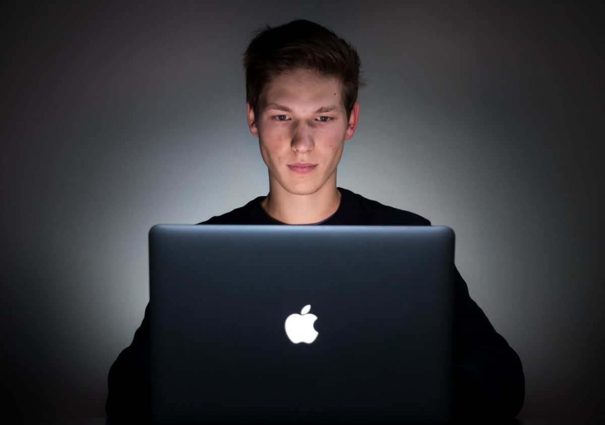 image of young man sitting a MacBook Pro laptop used with story Marty Doesn't Miss written by JeniseCook.com